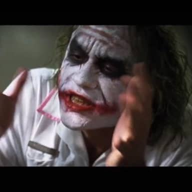 And Everybody Loses Their Minds meme template: A chaotic close-up of the Joker in a white shirt, with his face painted, making frantic gestures with his hands.