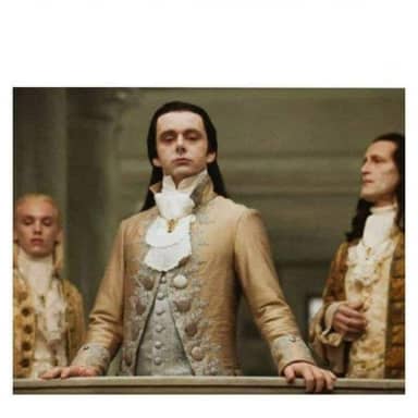 Aristocracy meme template: A man in ornate 18th-century attire with long dark hair stands with his hands on a railing, looking stoically forward. Two other men in similar attire are visible behind him.