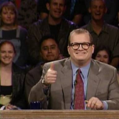 And The Points Don't Matter meme template: A man in a suit and glasses gives a thumbs up while sitting behind a desk, with a blurred audience behind him.