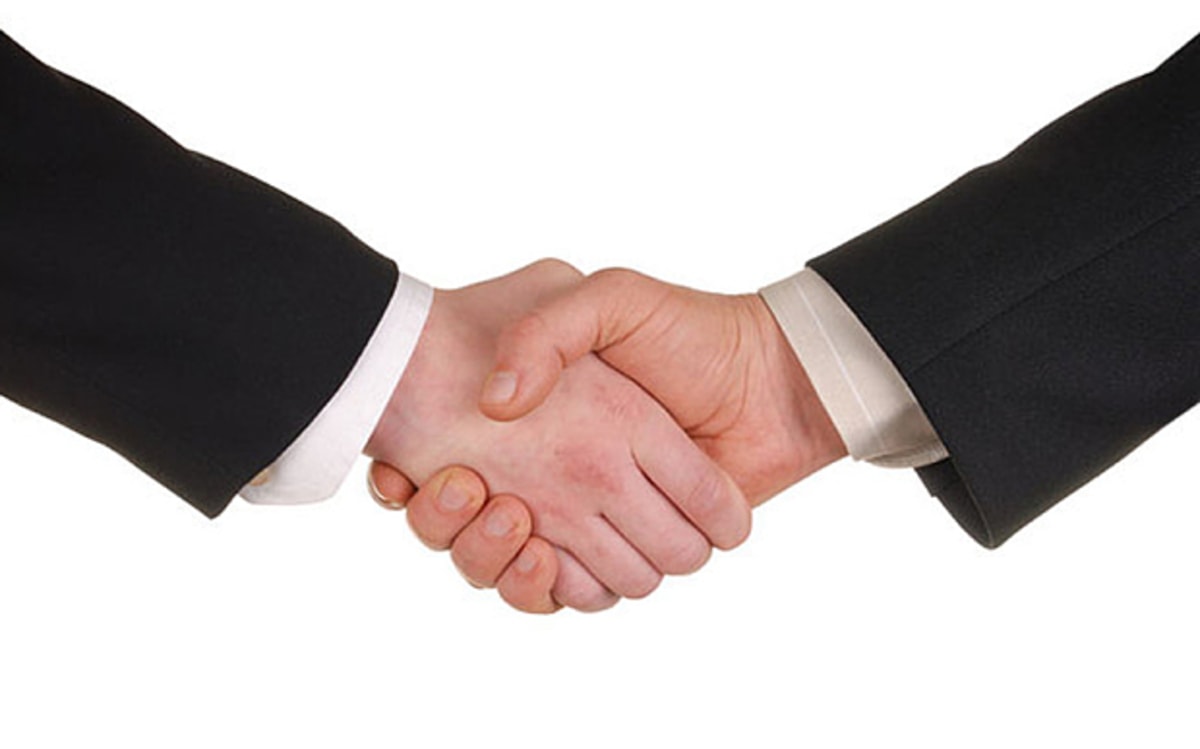 Business Handshake meme template: A close-up shot of two men in suits shaking hands firmly.