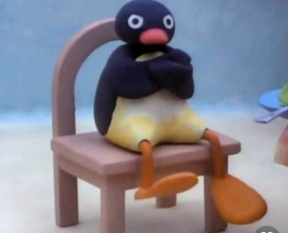 Angry Pingu meme template: A claymation penguin named Pingu sits on a small chair with his arms crossed and a stern, annoyed expression.