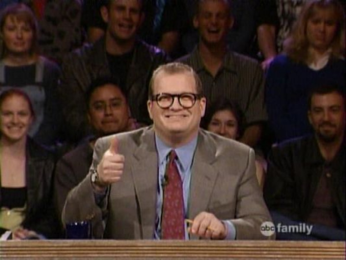 And The Points Don't Matter meme template: A man in a suit and glasses gives a thumbs up while sitting behind a desk, with a blurred audience behind him.