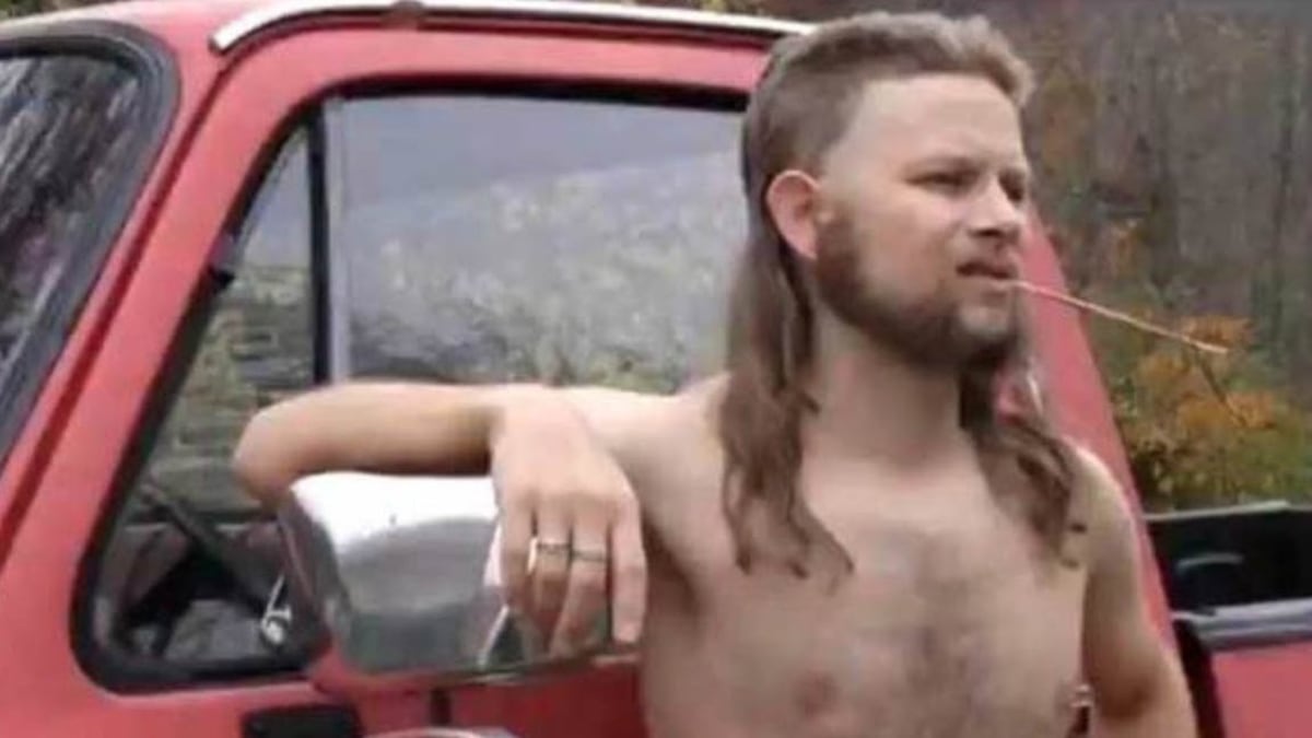Almost Politically Correct Redneck meme template: A shirtless man with a mullet and beard is leaning on the side of a red pickup truck, chewing on a twig.