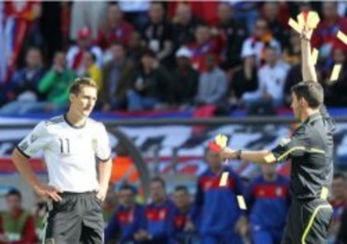 Asshole Ref meme template: A soccer referee holds up multiple yellow cards to a player who looks unimpressed.