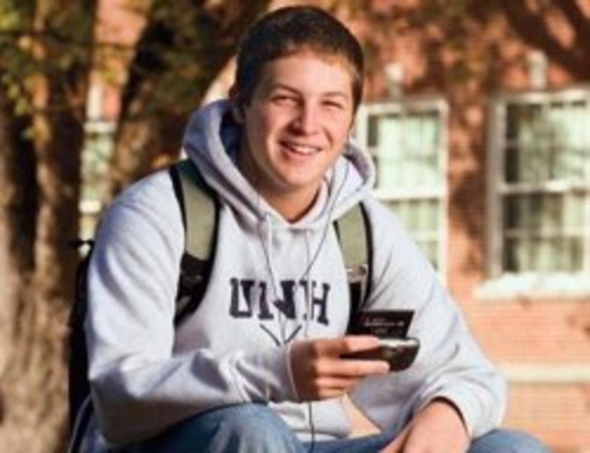 College Freshman meme template: A young man with a backpack and earbuds, holding a portable music player, looks happy and oblivious.