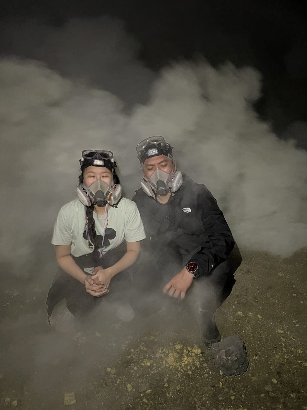 2 humans with very strong smoke in background 