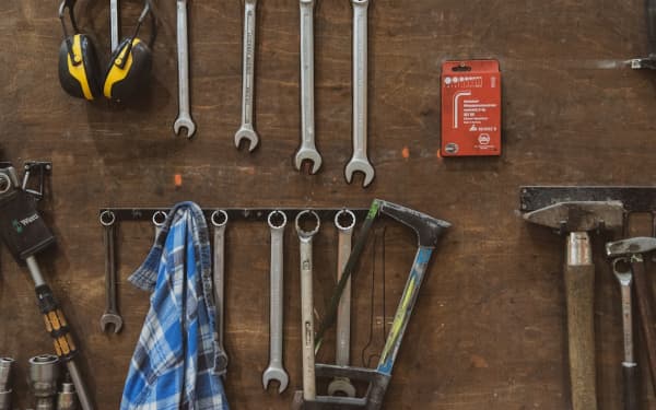 Wrenches and hand tools hanging on a workshop wall