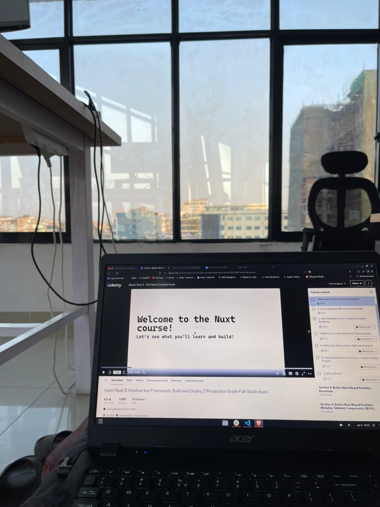 Laptop on a desk by a window, playing a Nuxt course