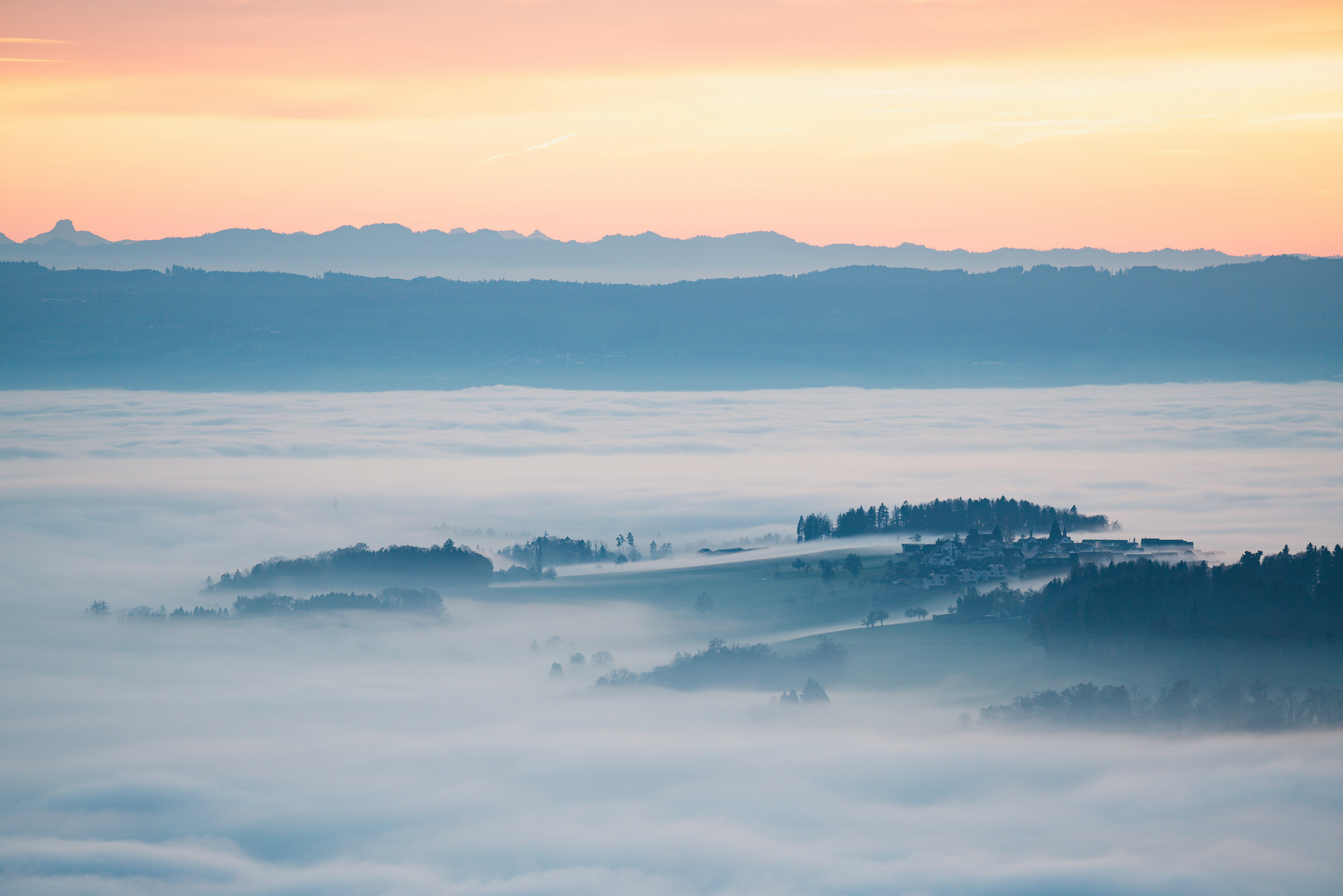 Fog rolling over mountain peaks at dawn