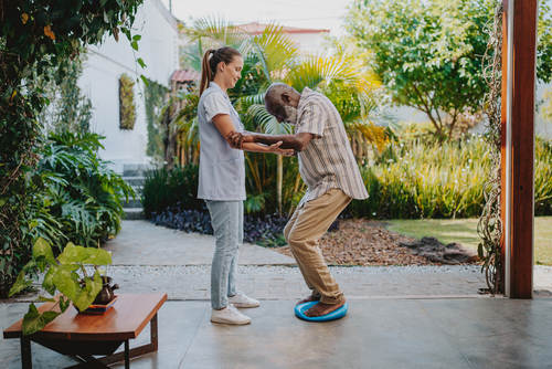 Fizyoterapist yaşlılar için hareket tedavisi uyguluyor.