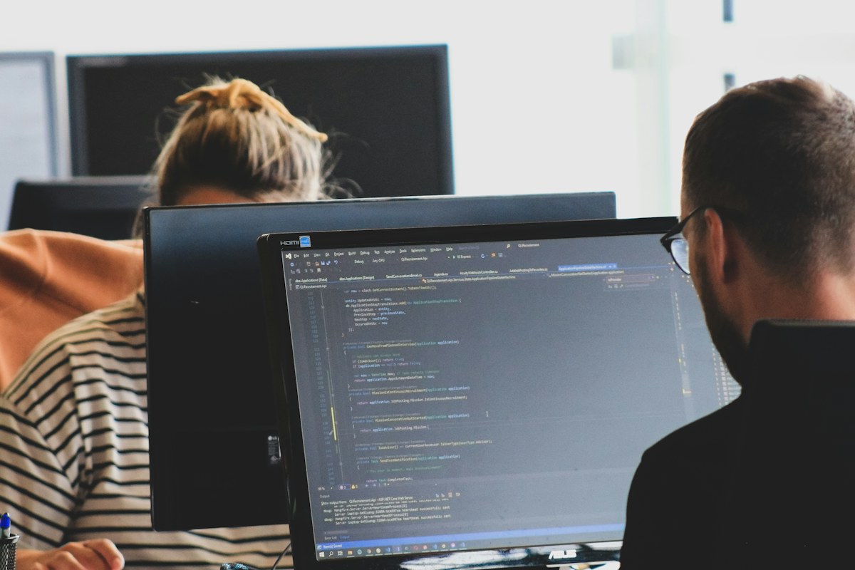 Two developers reviewing code at computer monitors
