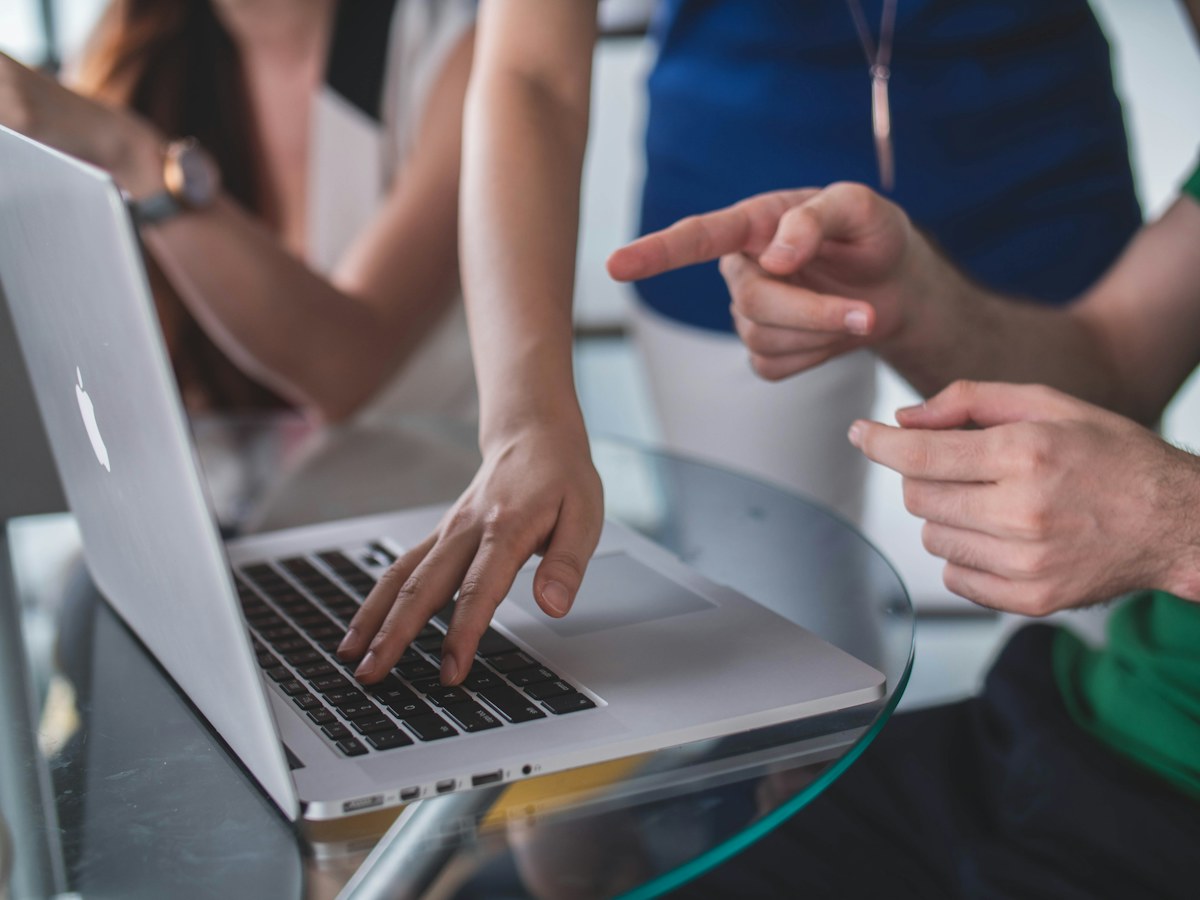 Colleagues discussing information on a laptop