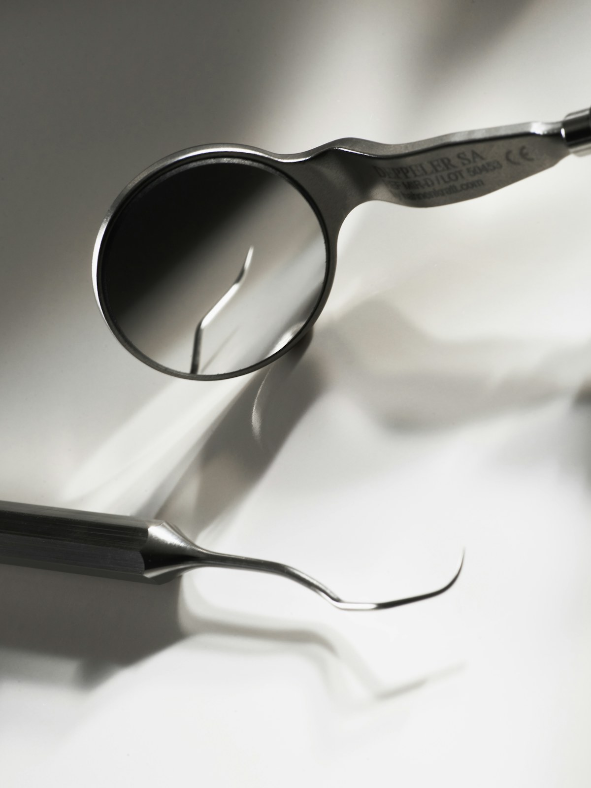 Dental mirror and explorer instrument on a clean surface