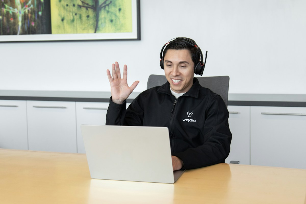 Person wearing headphones while using a laptop