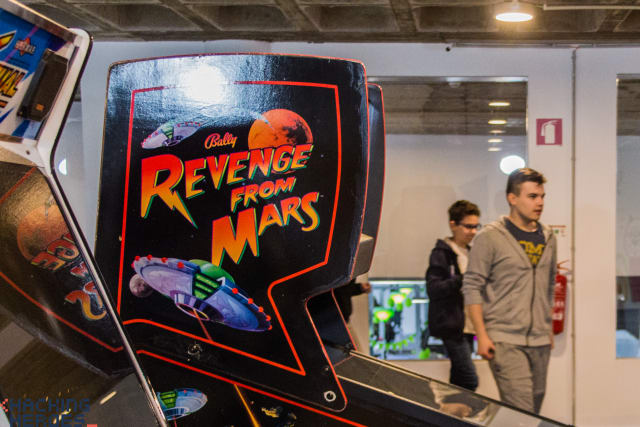 A participant standing beside an arcade cabinet