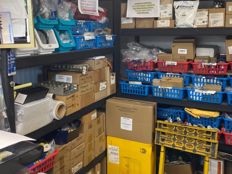 Heating element kits, boxed parts and blue bins of repair parts on the shelves at Barn Appliances