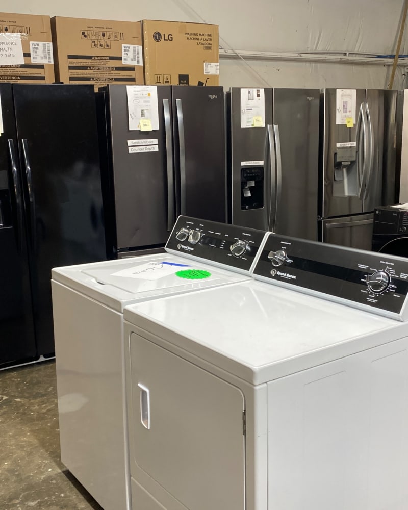 A white Speed Queen top-load washer and matching dryer on the showroom floor at Barn Appliances