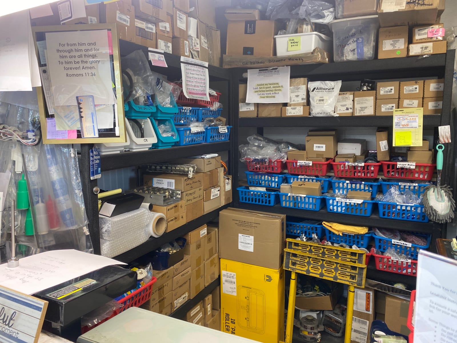 Shelves of boxed appliance parts and labeled bins behind the counter at Barn Appliances in Leoma, TN