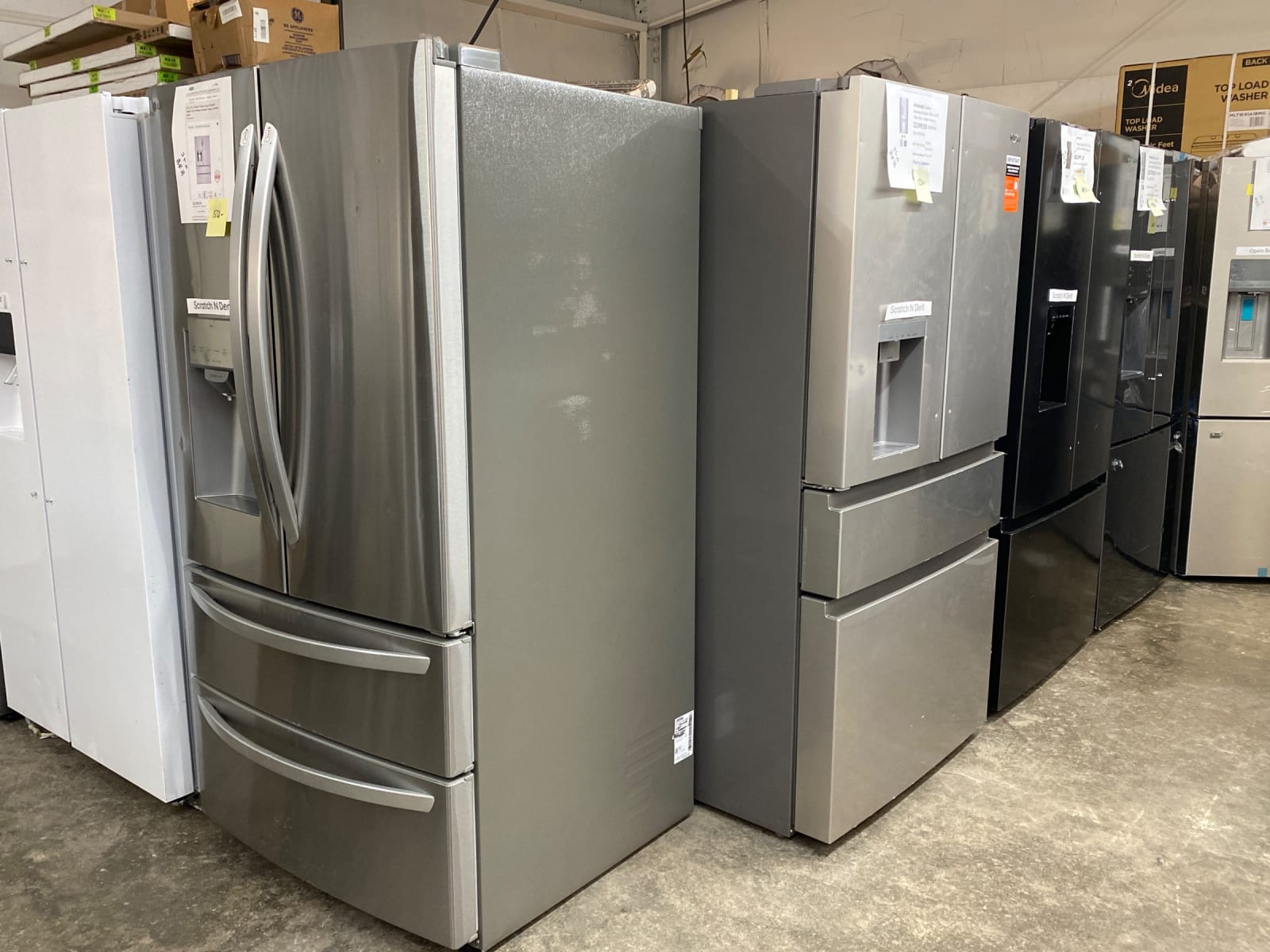 Stainless French-door refrigerators with Scratch N Dent labels on the showroom floor in Leoma, TN