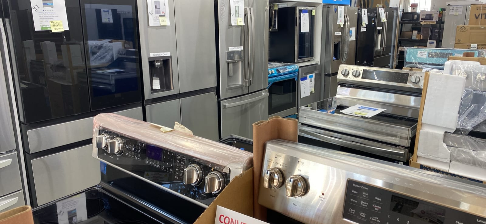 Stainless French-door refrigerators and new ranges lined up on the showroom floor at Barn Appliances in Leoma, TN