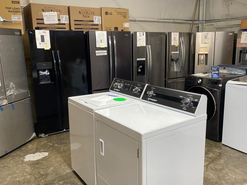 Black side-by-side and French-door refrigerators labeled Scratch N Dent and Counter Depth at Barn Appliances in Leoma