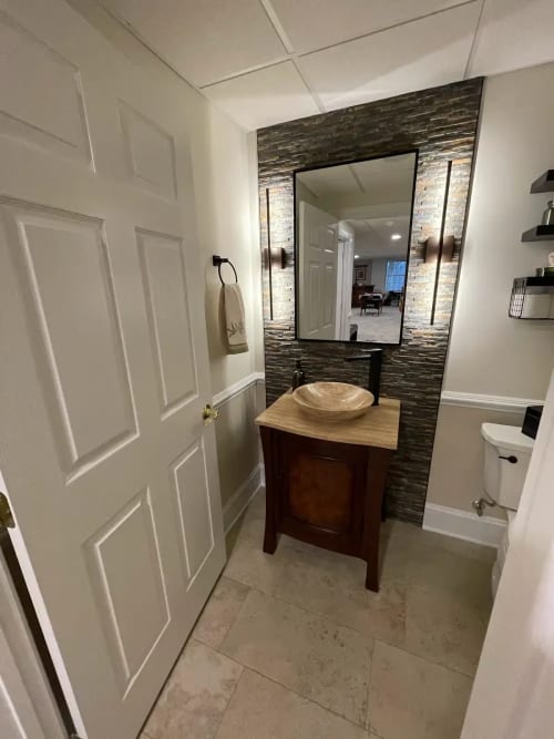 Denville NJ Bathroom 2 - Completed - Tile accent wall with stone bowl sink and stone countertop with accent wall lighting Denville NJ Bathroom 2 - Completed - Tile accent wall with stone bowl sink and stone countertop with accent wall lighting