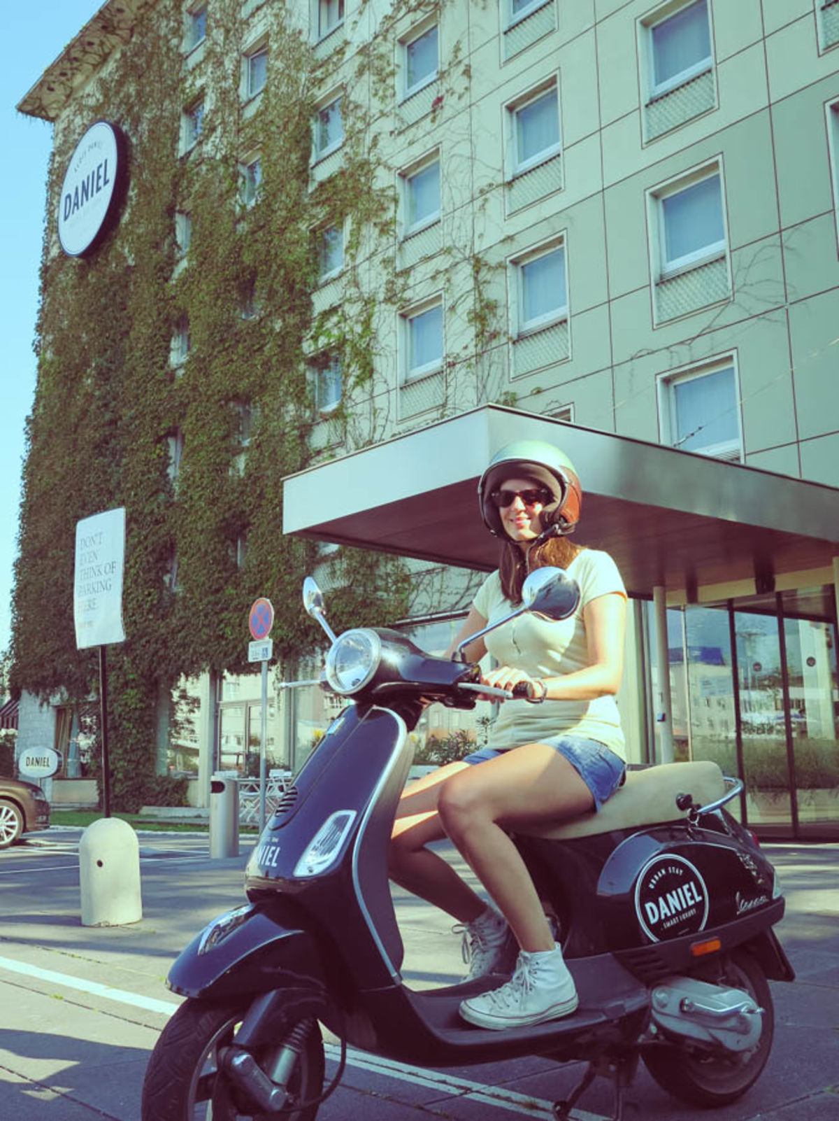 Frau auf Vespa vor dem Hotel Daniel