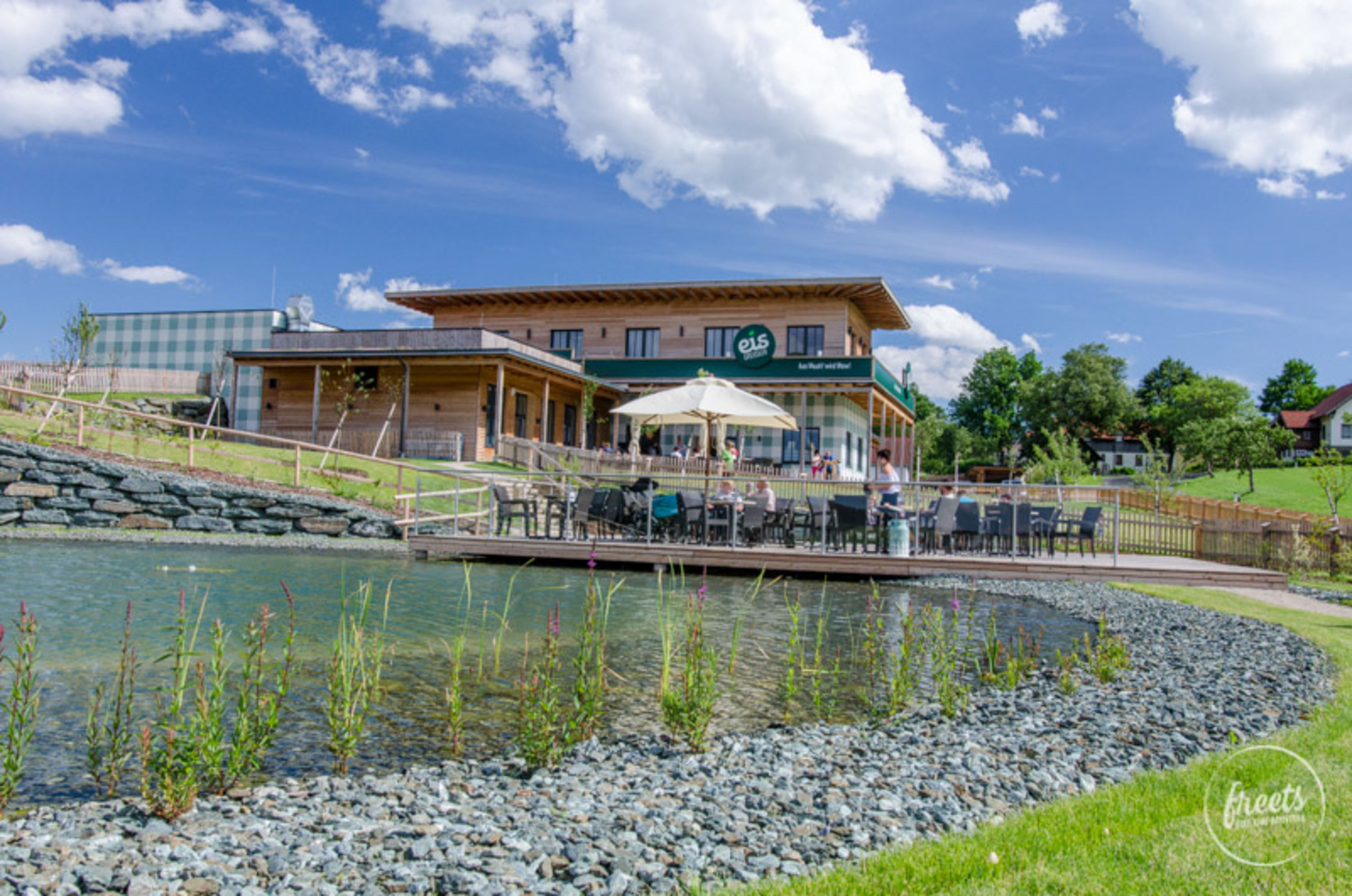 Eis Greissler von außen Teich und Terrasse vor dem Eis Greissler in Krumbach