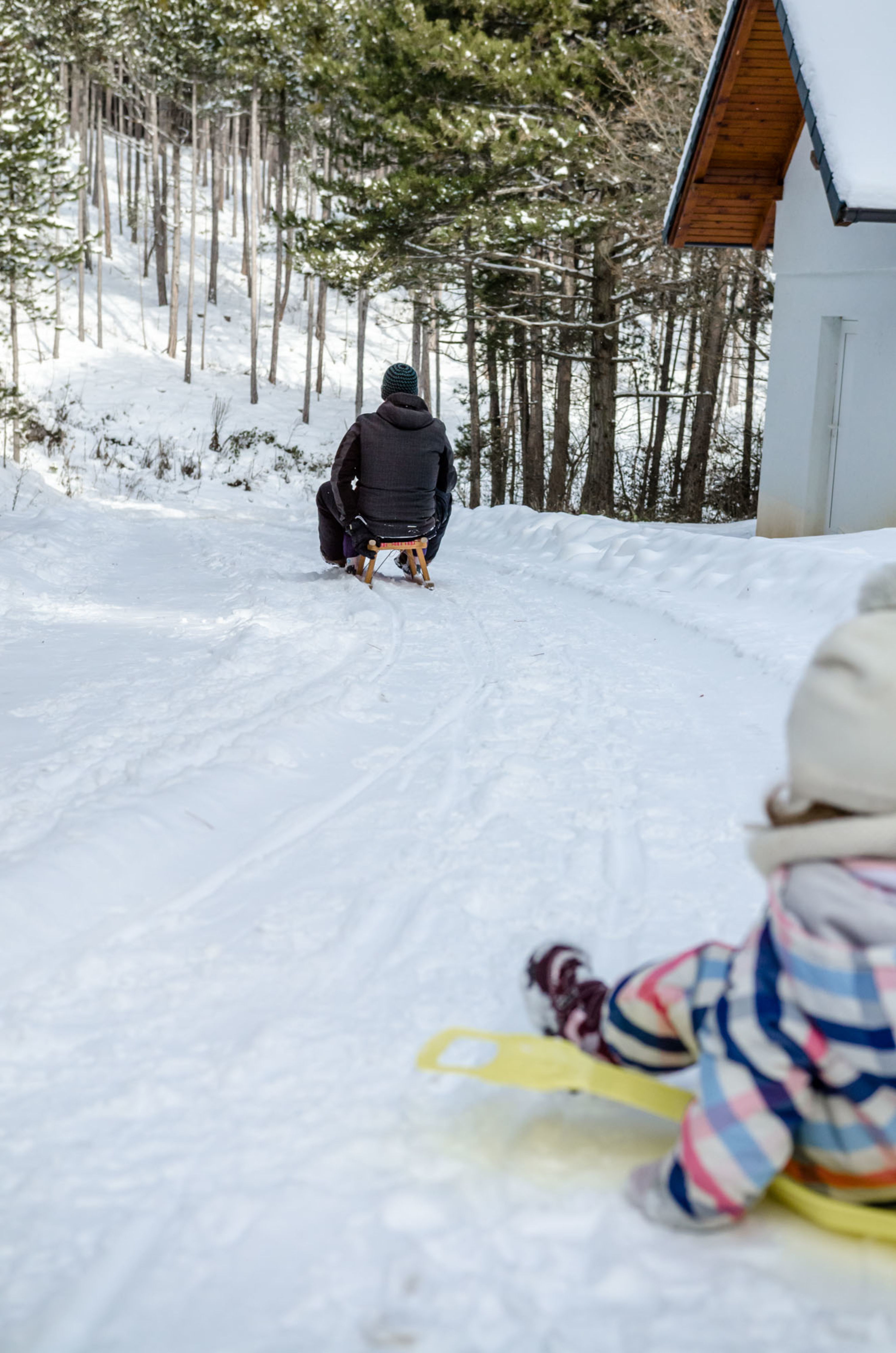 Rodeln in Würflach im Winter, Kleinkind mit Tellerbob