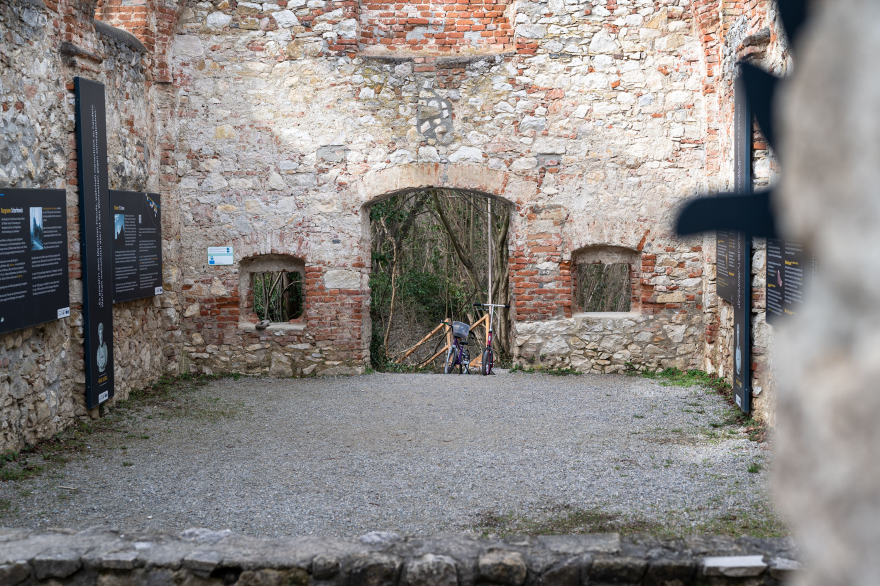 Blick durch die Johanneskapelle im Naturpark Wüste bei Mannersdorf am Leithagebirge, alte Mauern mit Rad und Roller