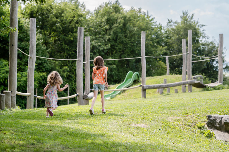 Spielplatz im Obstsortengarten bei Rohrbach bei Mattersburg, Kinder laufen über die Wiese