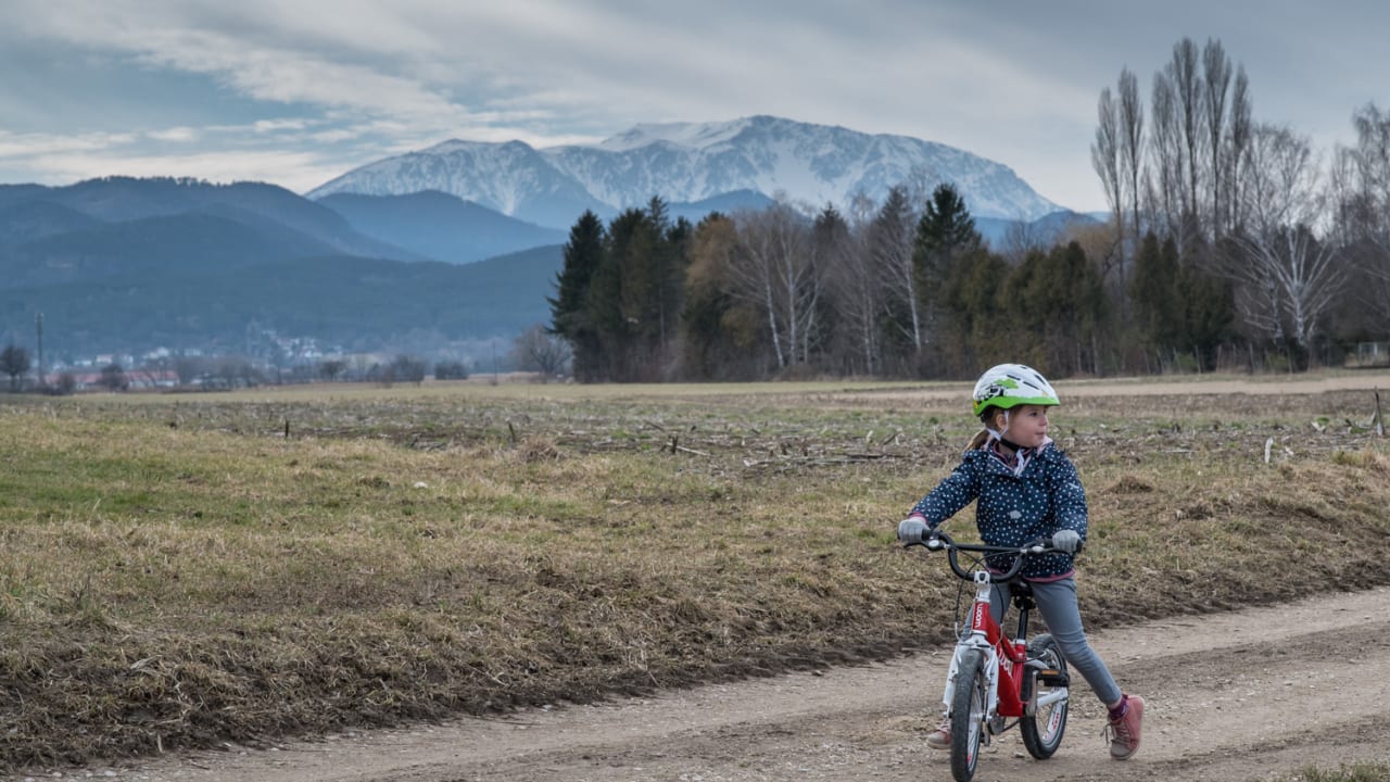 Kind mit Fahrrad auf einem Feldweg