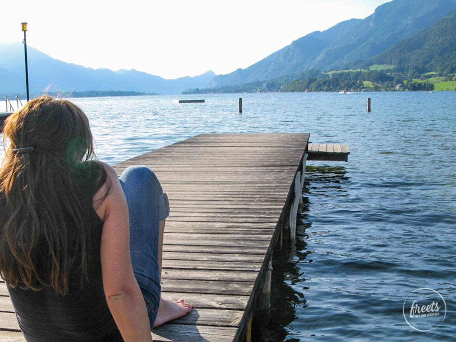 Steg in Strobl, Wolfgangsee Frau sitzt am Steg in Strobl am Wolfgangsee, Sommerurlaub