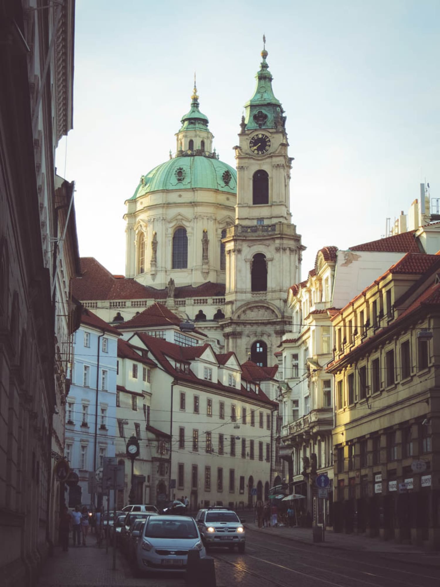 Kopfsteingepflasterte Straßen, niedrige Häuser und prunkvolle Kirchen erwarten dich auf der sogenannten Kleinseite in Prag. Hier im Hintergrund die barocke St. Nikolaikirche.