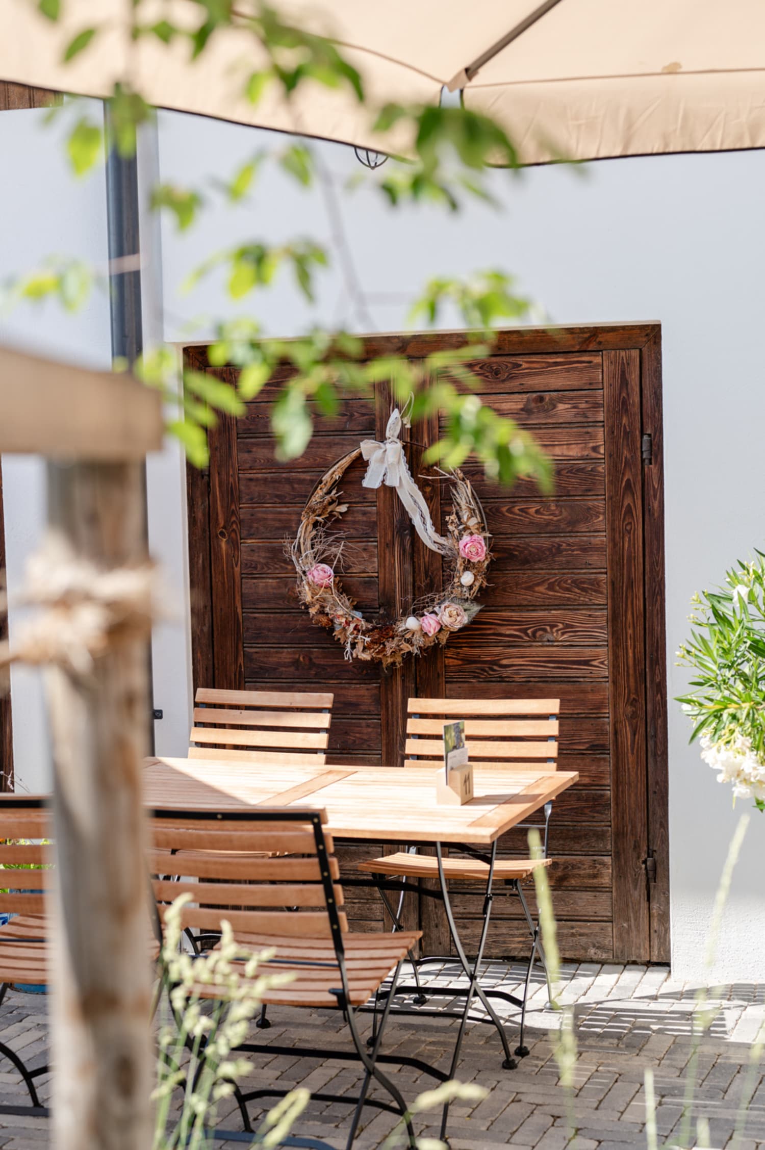 Tisch in der Weinwirtschaft Lassl in Sigleß, Holztor mit Blumenkranz