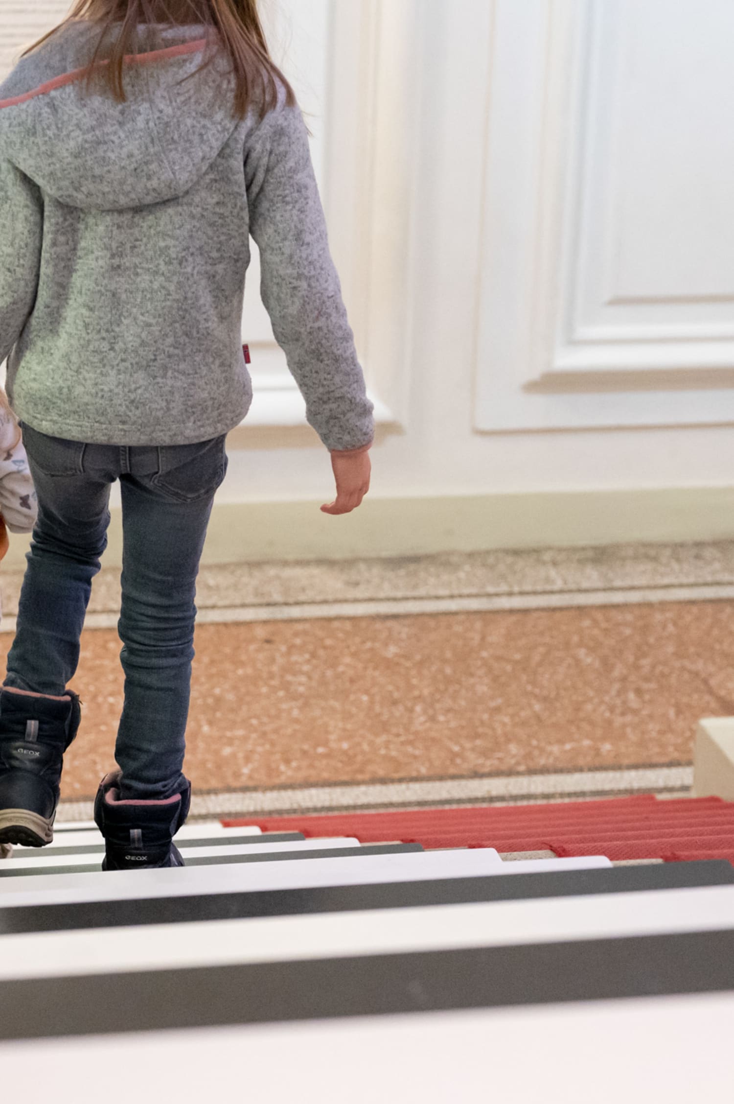 Kind läuft über die Klaviertreppe im Haus der Musik