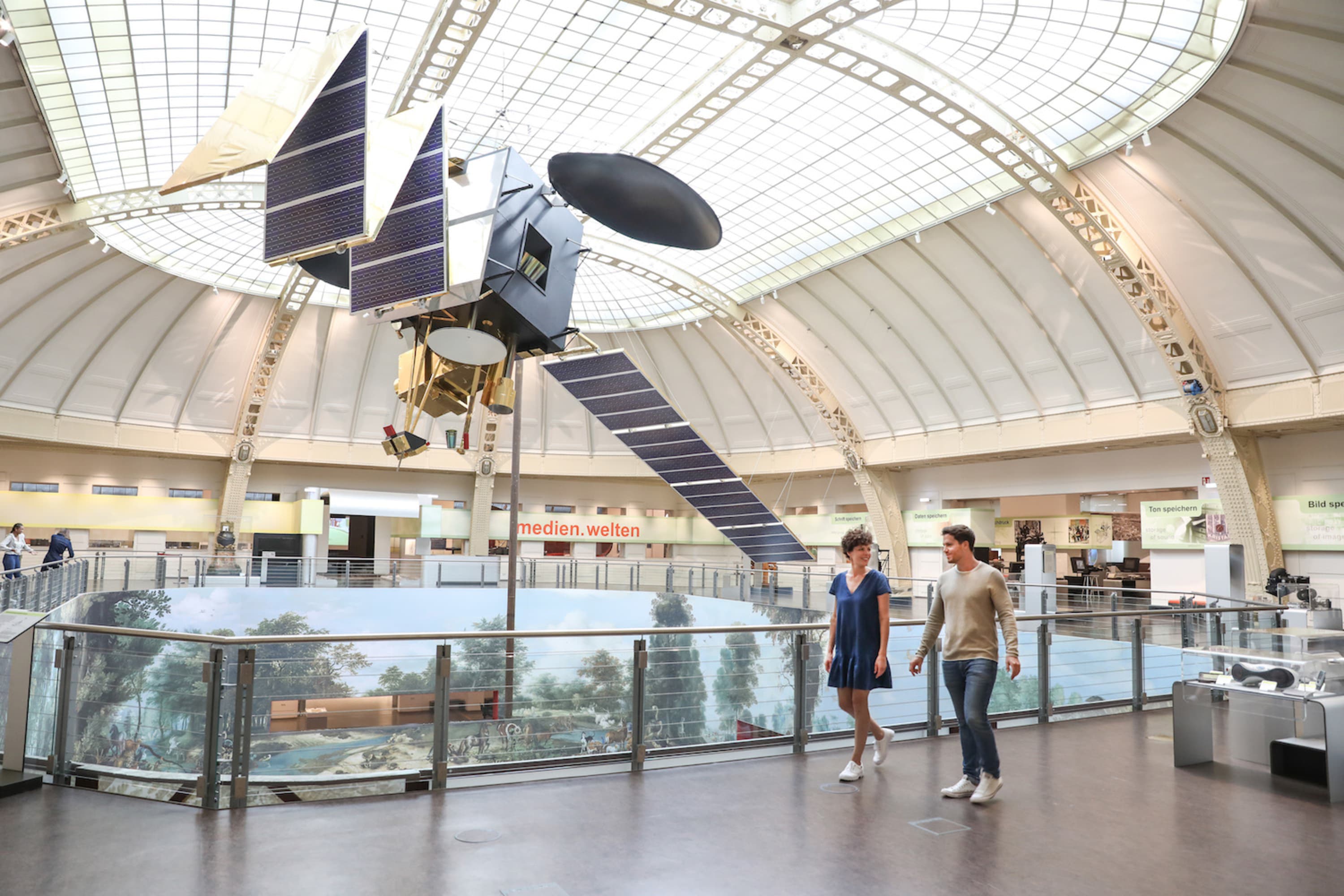 Modell des Kommunikationssatelliten ARTEMIS im Maßstab 1:1 mit Museumsbesucher