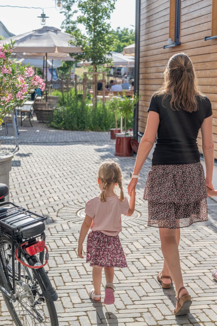 Mama und Kind gehen in die Weinwirtschaft Lassl, Sigleß