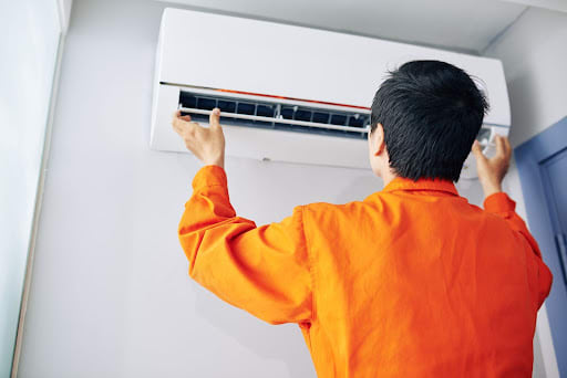 Man checks air conditioning unit on wall