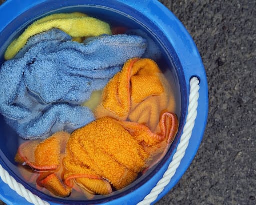 Bucket of water with colorful cleaning towels