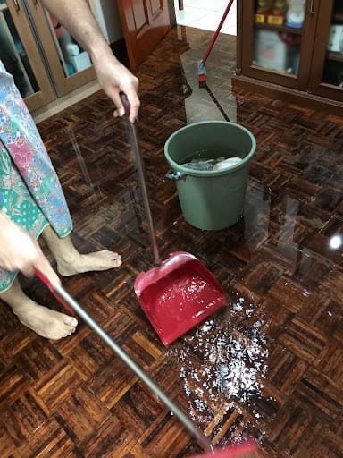 Person cleans up flooded water on home floor