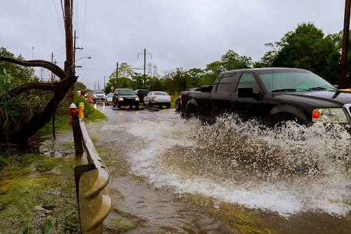 Truck drives over flooded rain water