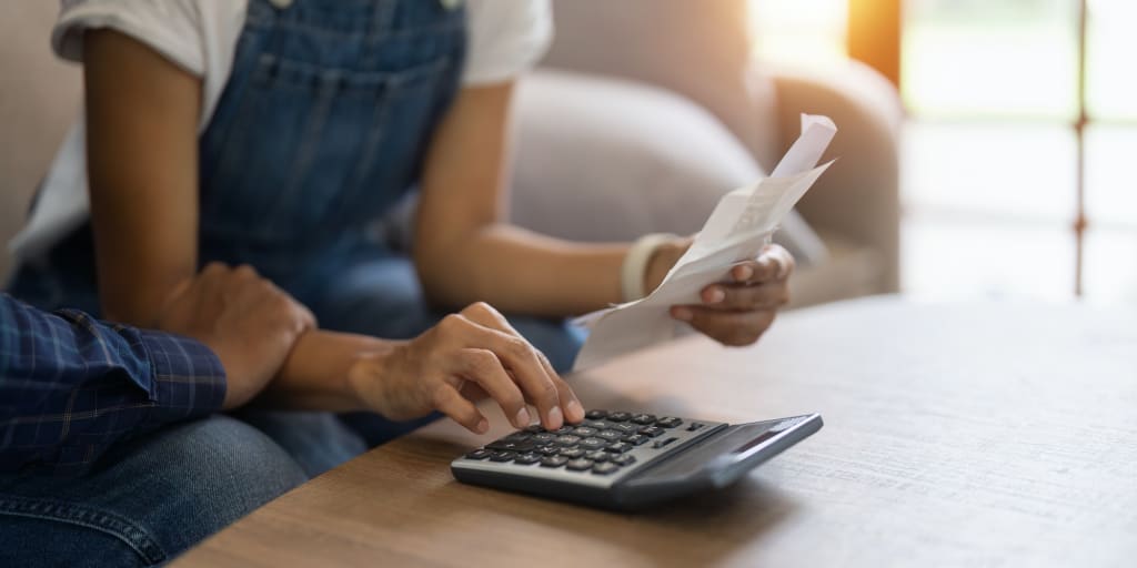 Married couple sit on couch read financial papers invoices trouble with too high expense utility