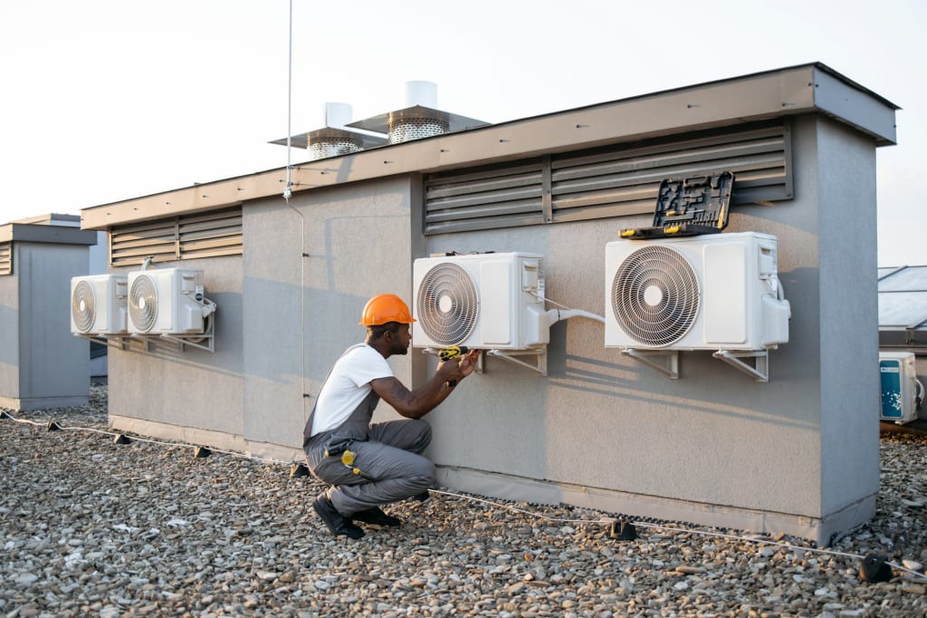 Construction worker fixing conditioner with drill outdoor