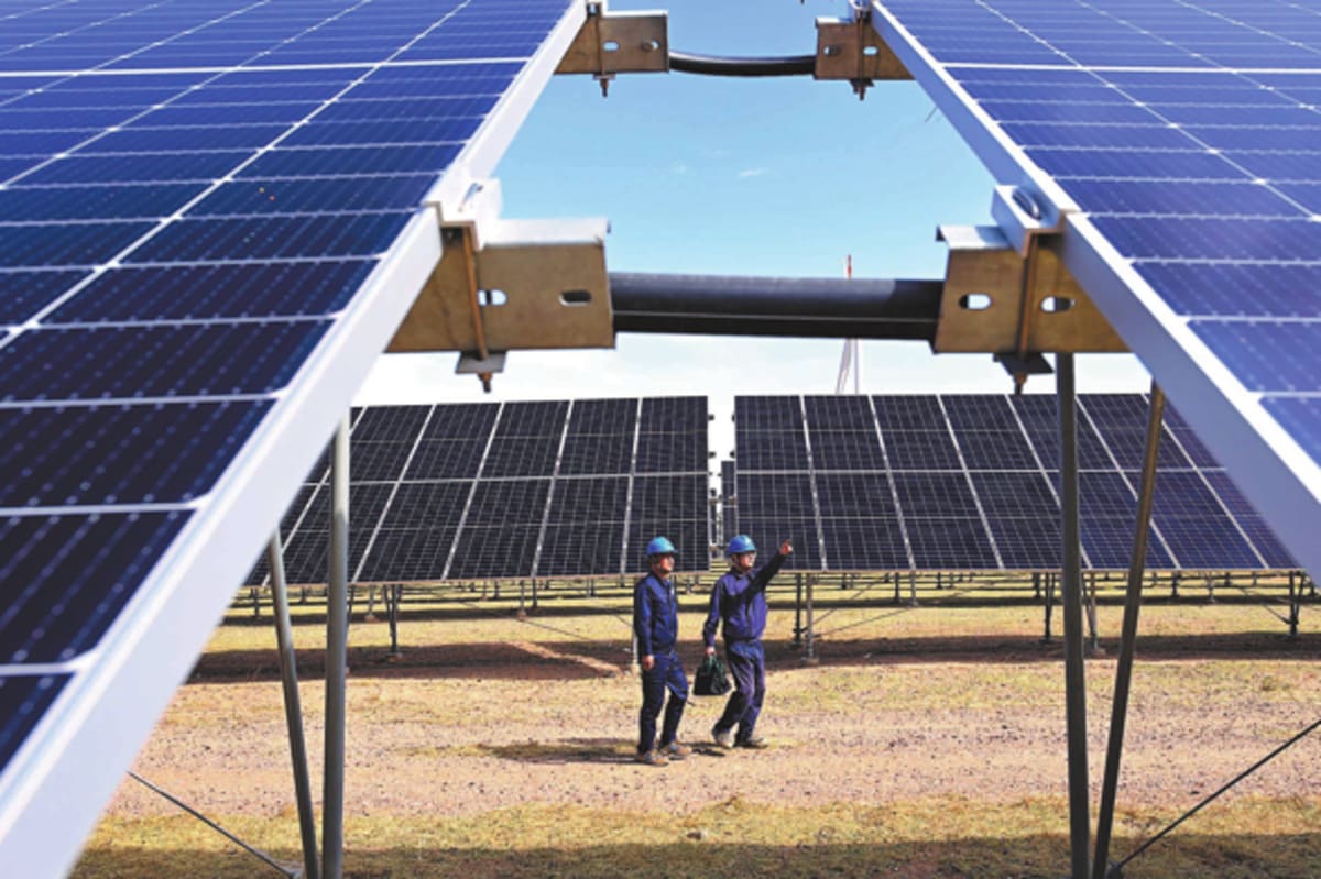 ** High-voltage transmission towers stretching across landscape carrying renewable electricity through modern power grid