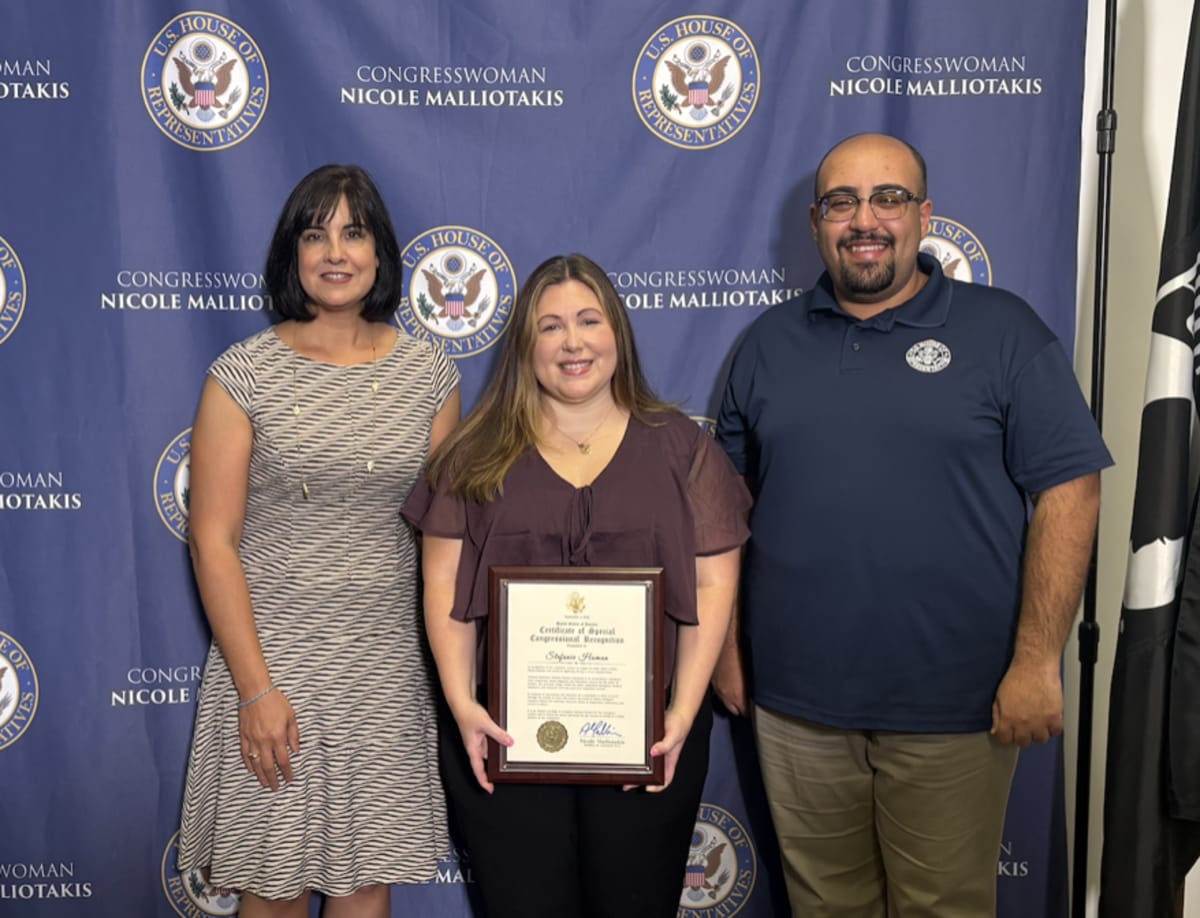 Congresswoman presenting Congressional Commendation certificate to woman who rescued lightning strike victim