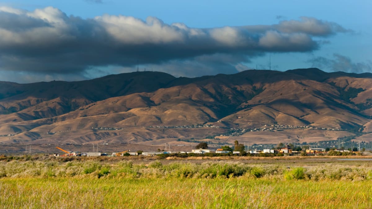 Clouds over green Milpitas Hills showing natural landscape near developing community