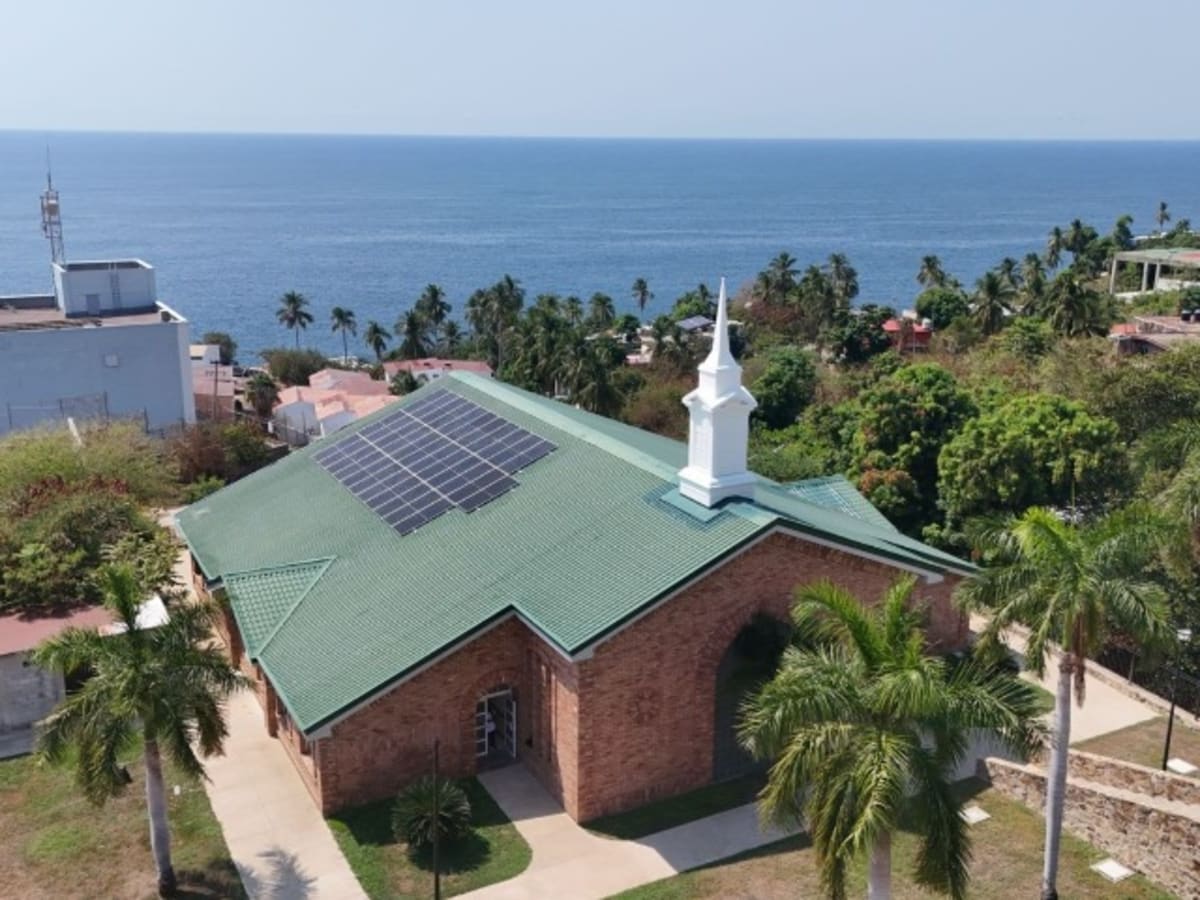 Solar panels installed on rooftop of white Church meetinghouse building in Acapulco, Mexico