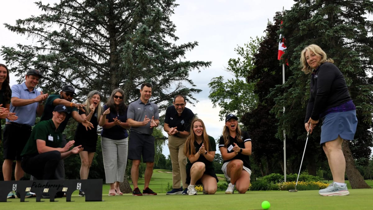 University president putts golf ball before fundraising tournament start at country club