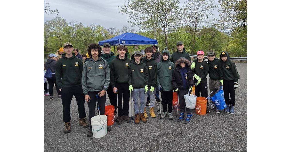 ** Boy Scouts in uniforms collecting trash bags during Rahway River watershed cleanup event